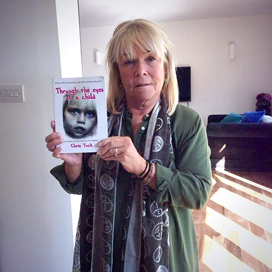 Linda Robson holding a book, Through the eyes of a child by Chris Tuck, Author